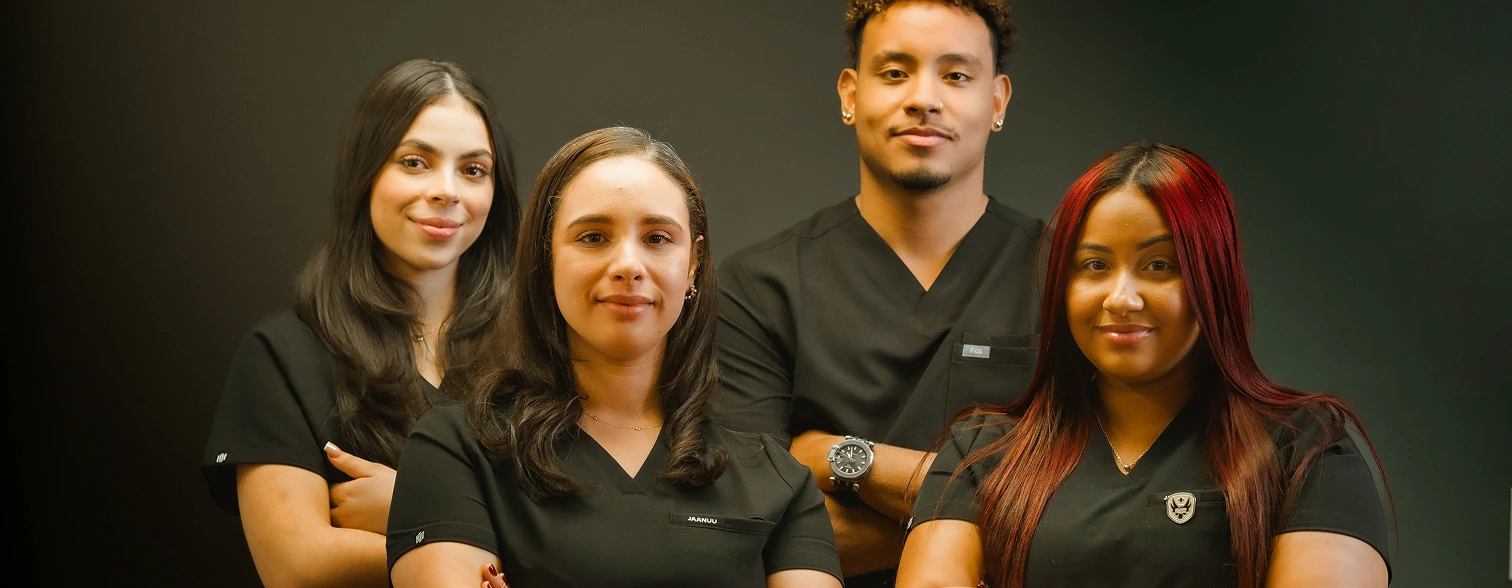 Four caregivers in medical uniforms posing together