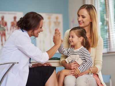 Medical professional interacting with a child and parent.