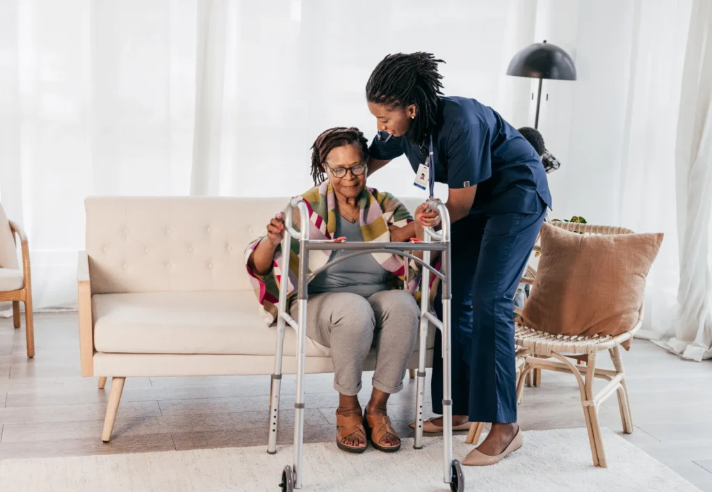 Caregiver assisting a resident with a walker.