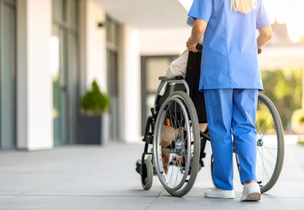 Healthcare worker assisting a resident in a wheelchair.