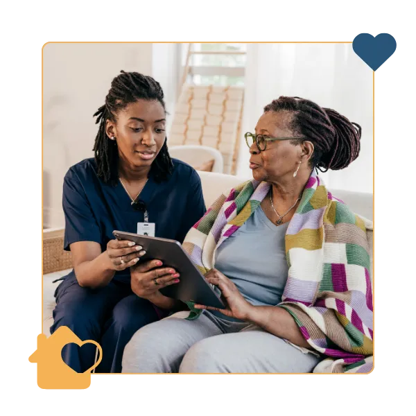 Caregiver assisting a senior woman with a tablet.