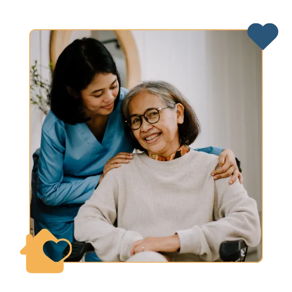 Caregiver smiling with elderly resident indoors