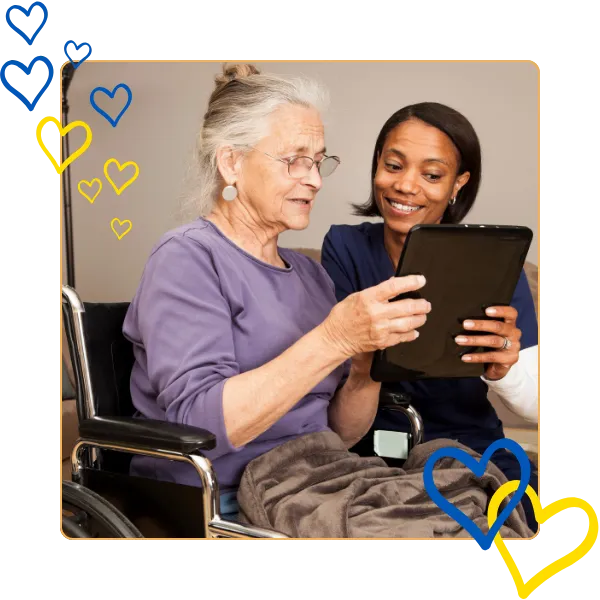 Resident and caregiver engaged with a tablet.