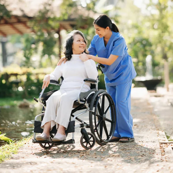 Caregiver assisting a resident in a garden.