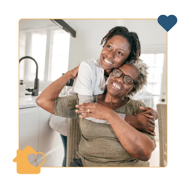 Caregiver embracing a senior in a cozy interior space.