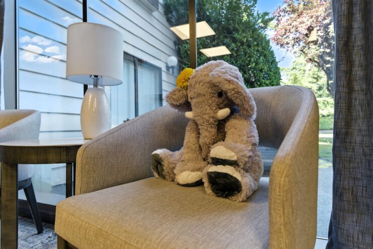 A stuffed elephant on a chair in a lounge area.