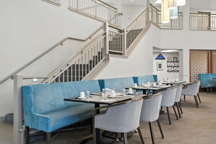 Dining area with elegantly set tables and blue seating.