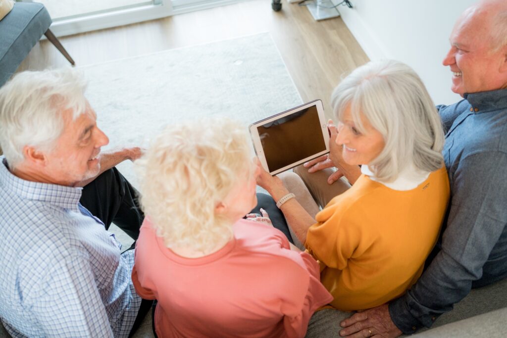 Seniors engaging around a tablet in a common area