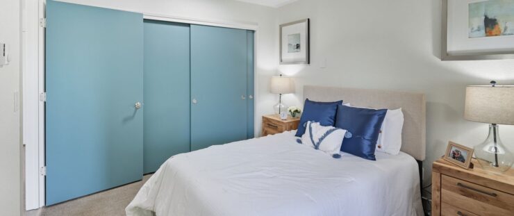 Cozy bedroom with blue accents and warm lighting.