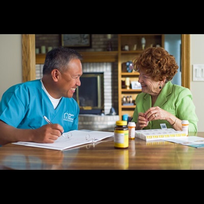 Caregiver and elderly woman in a friendly conversation.