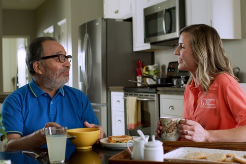 Caregiver and resident enjoying a meal together.