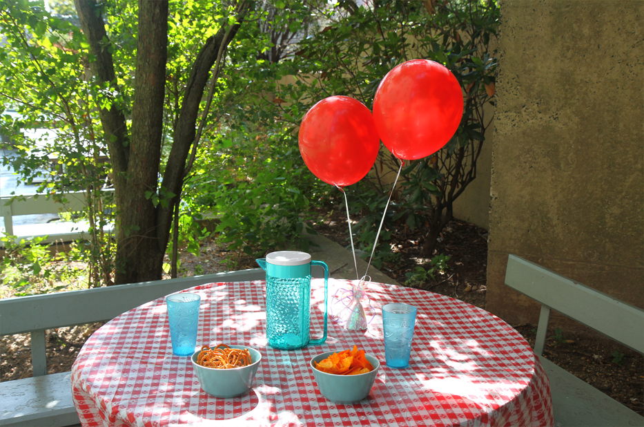 Outdoor table set with food and balloons
