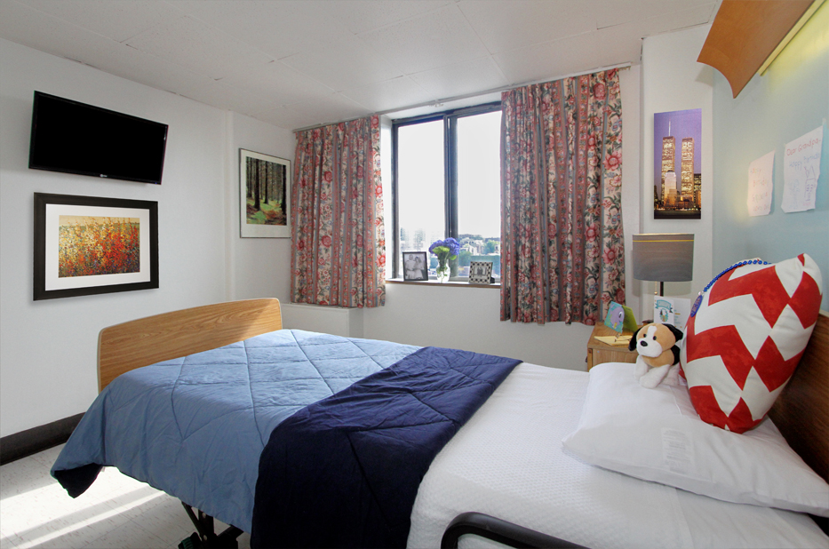 Cozy resident room with bed, window, and decor.