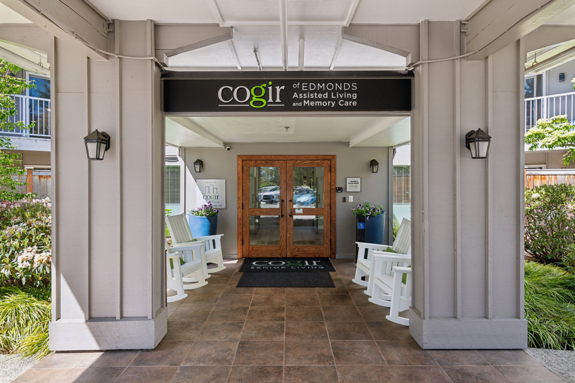 Entrance to Cogir of Edmonds with rocking chairs and signage