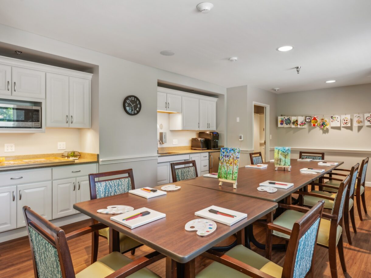 Bright common area with a large dining table and art on the walls