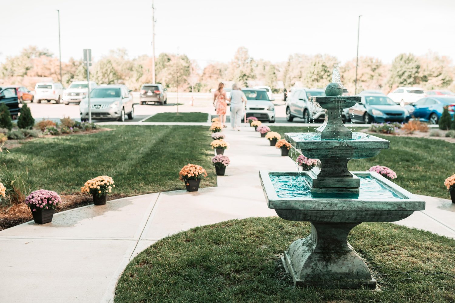 Pathway with fountain and flowers outside the facility