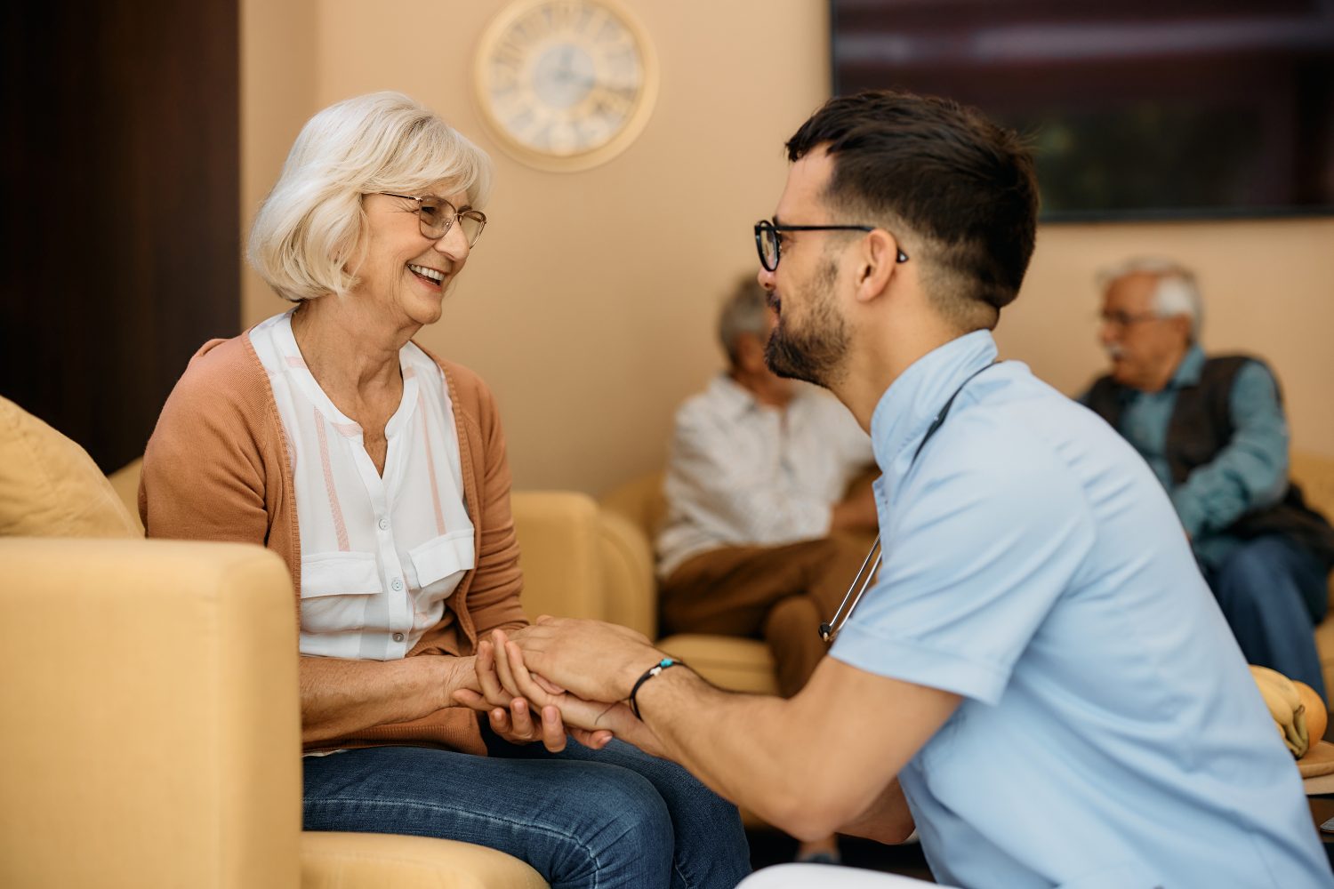 Staff member interacting with a smiling resident in a cozy setting