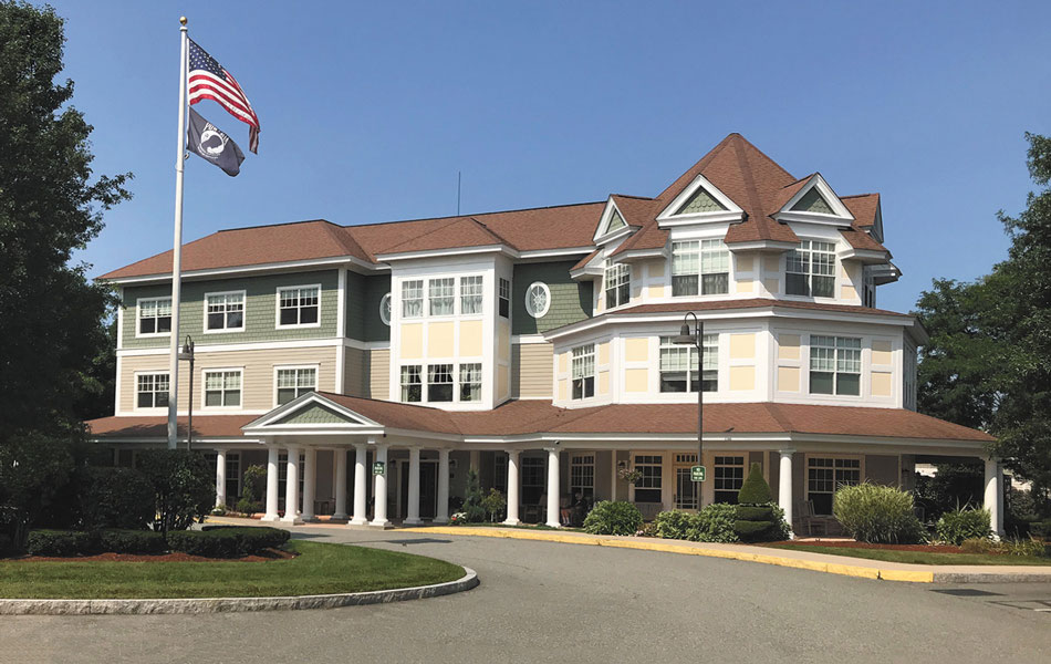 Front exterior of Tamarisk Senior Living with American flag