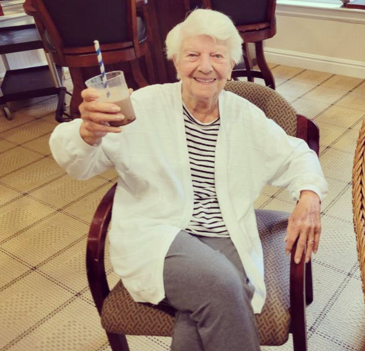 Resident enjoying a drink in a cozy chair