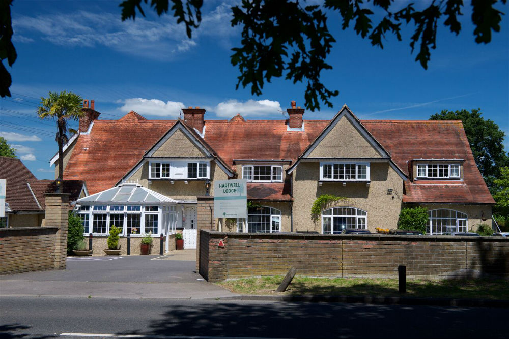 Exterior view of a residential care facility with greenery