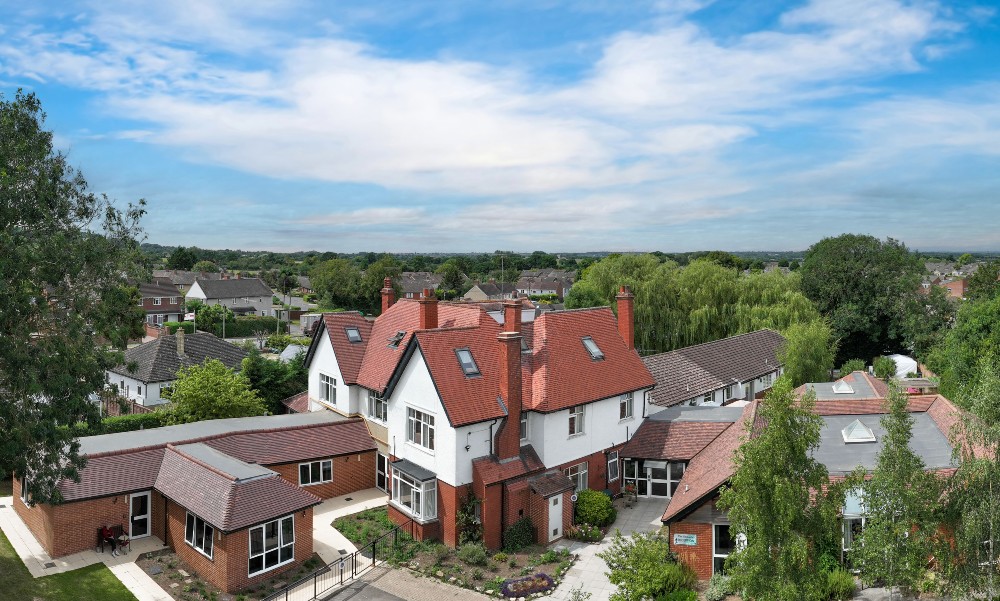 Aerial view of a residential care home surrounded by greenery