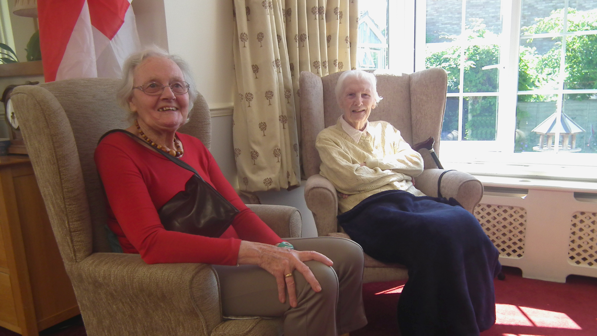 Two residents enjoying time in a cozy lounge area
