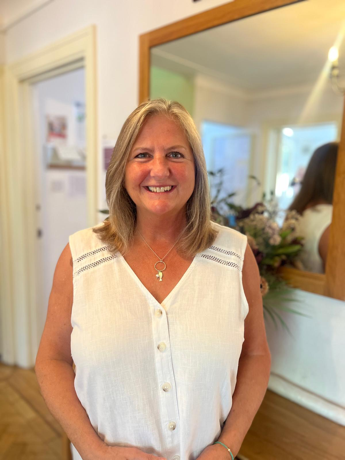 Staff member smiling in a bright interior setting