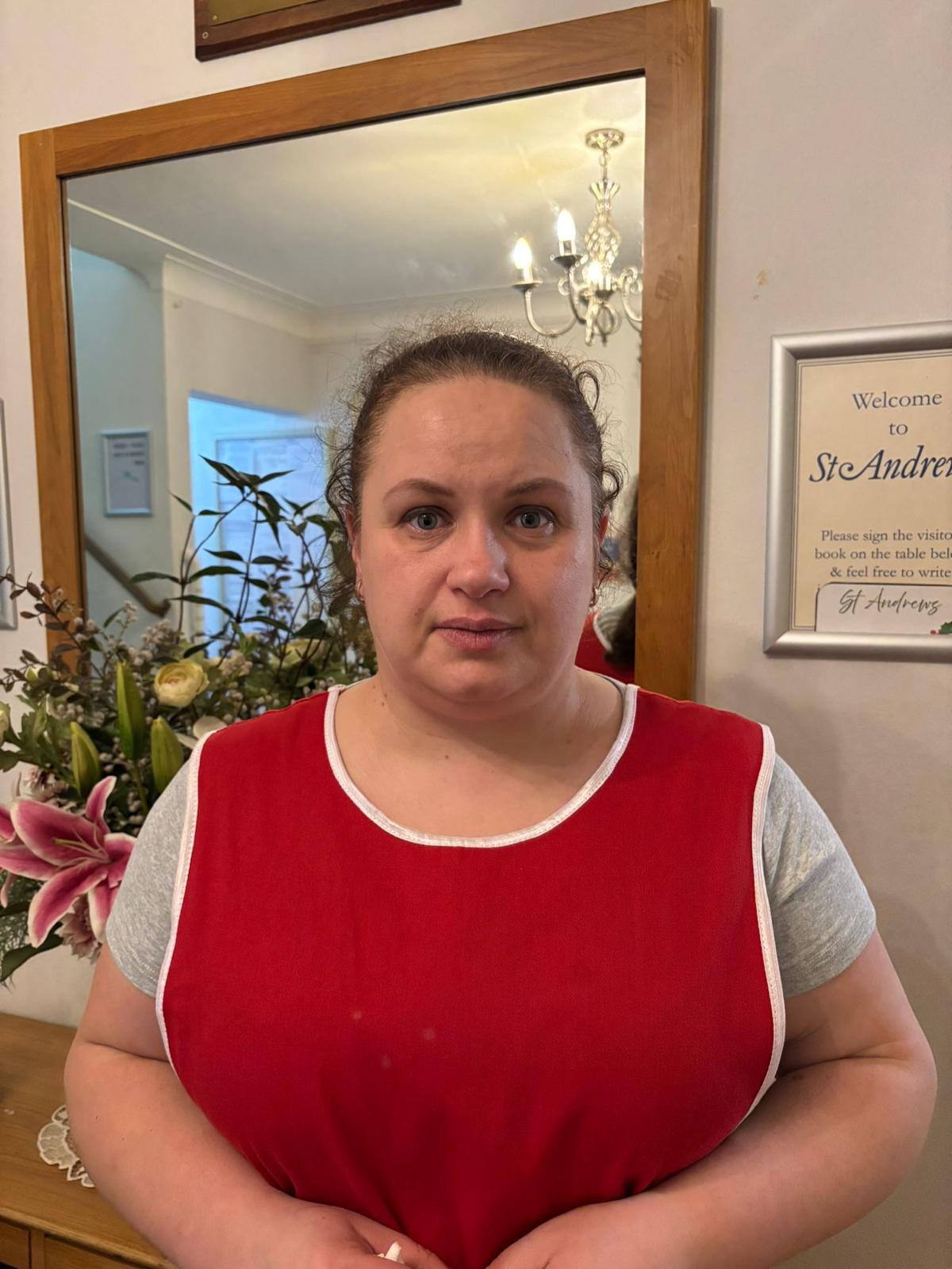 Staff member in a red uniform inside the facility