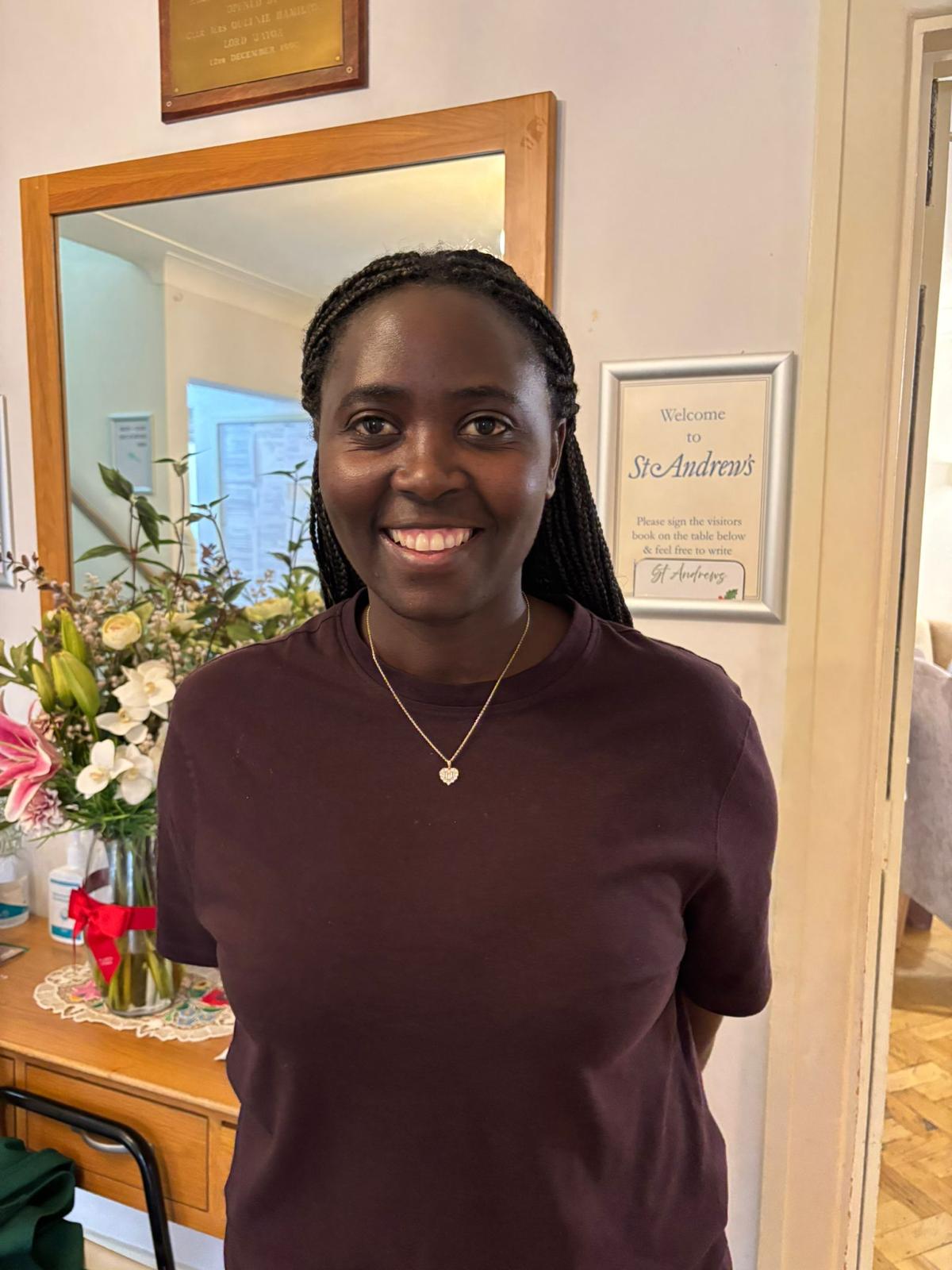Staff member smiling in a welcoming interior space