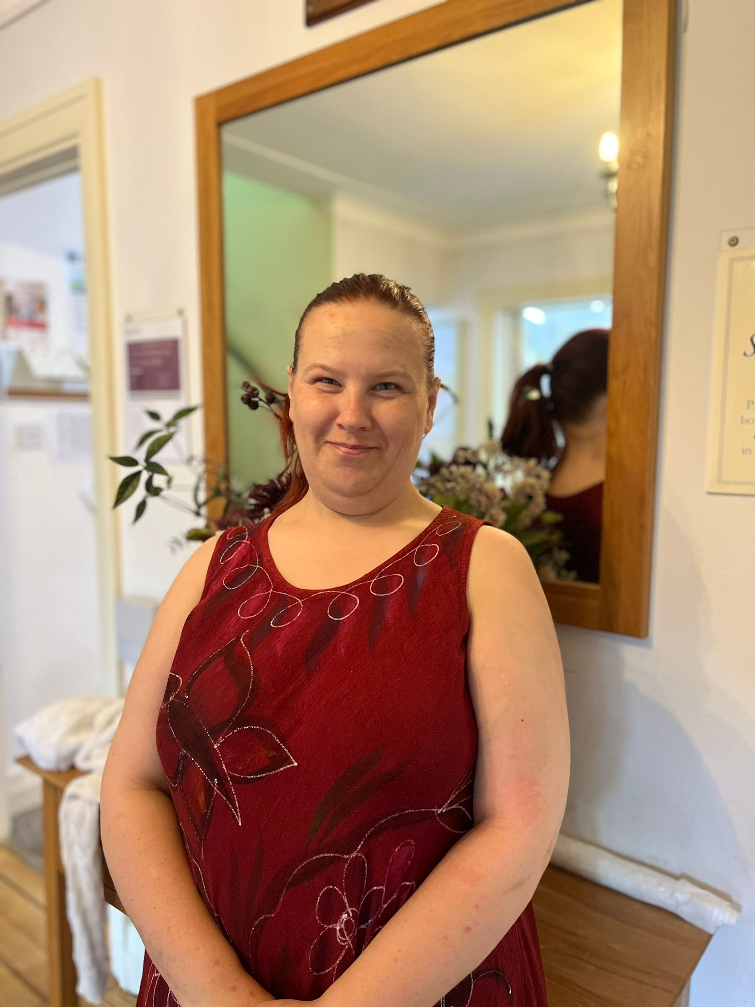 Staff member posing in a lobby area with mirror
