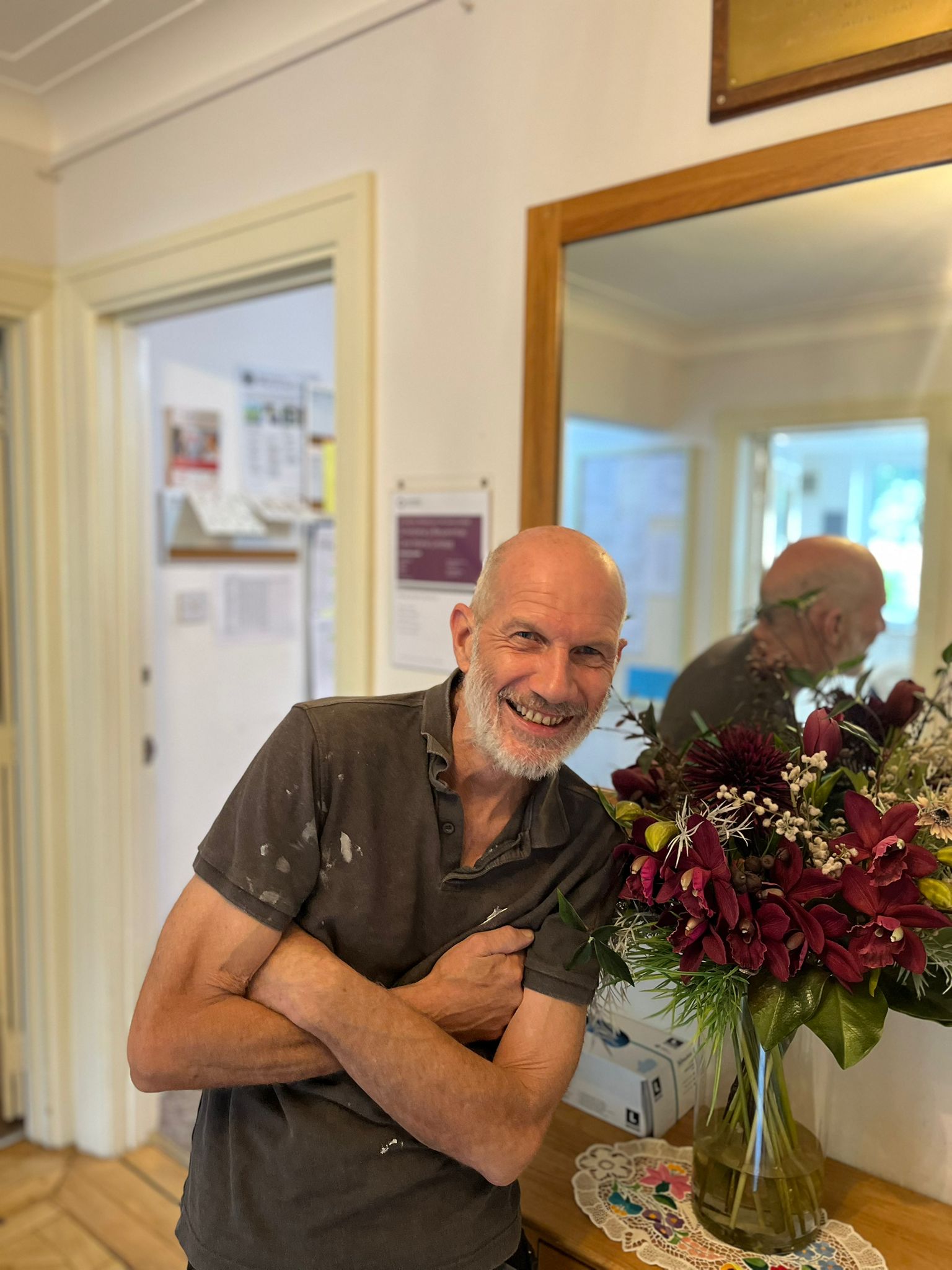 Resident smiling in a bright interior space with flowers