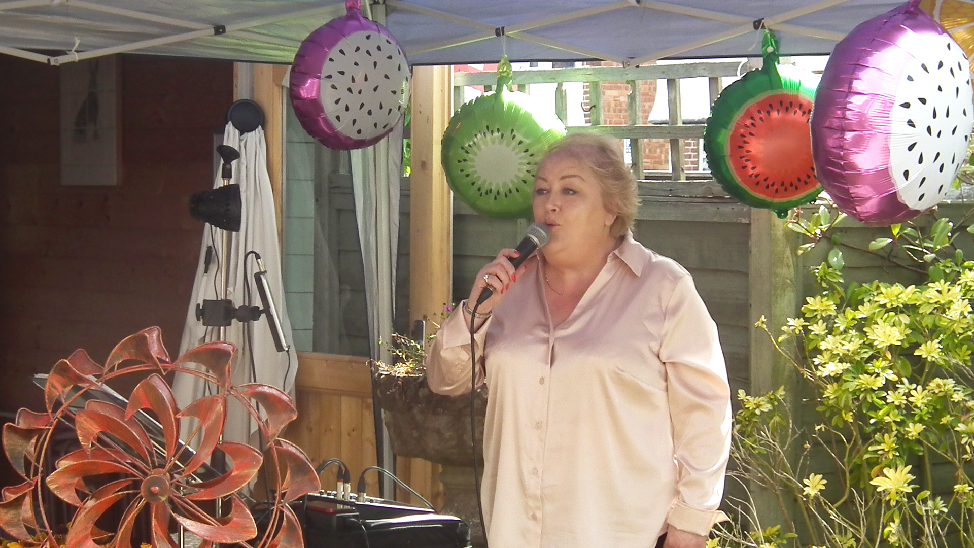 A woman singing at an outdoor celebration event