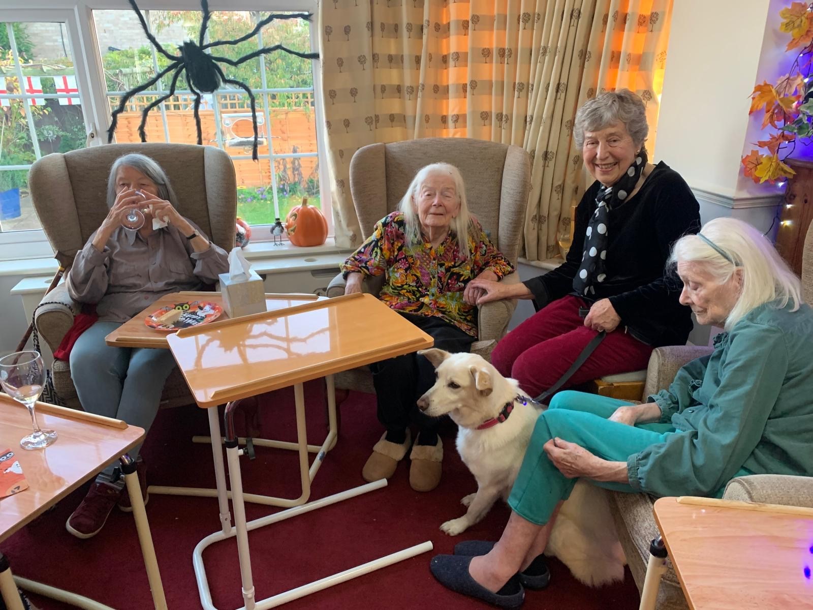 Residents enjoying time in a cozy lounge with a dog