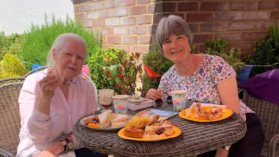 Two residents enjoying snacks outdoors