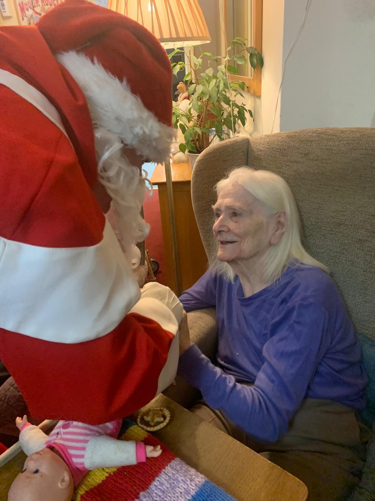Resident interacting with Santa Claus during a festive event