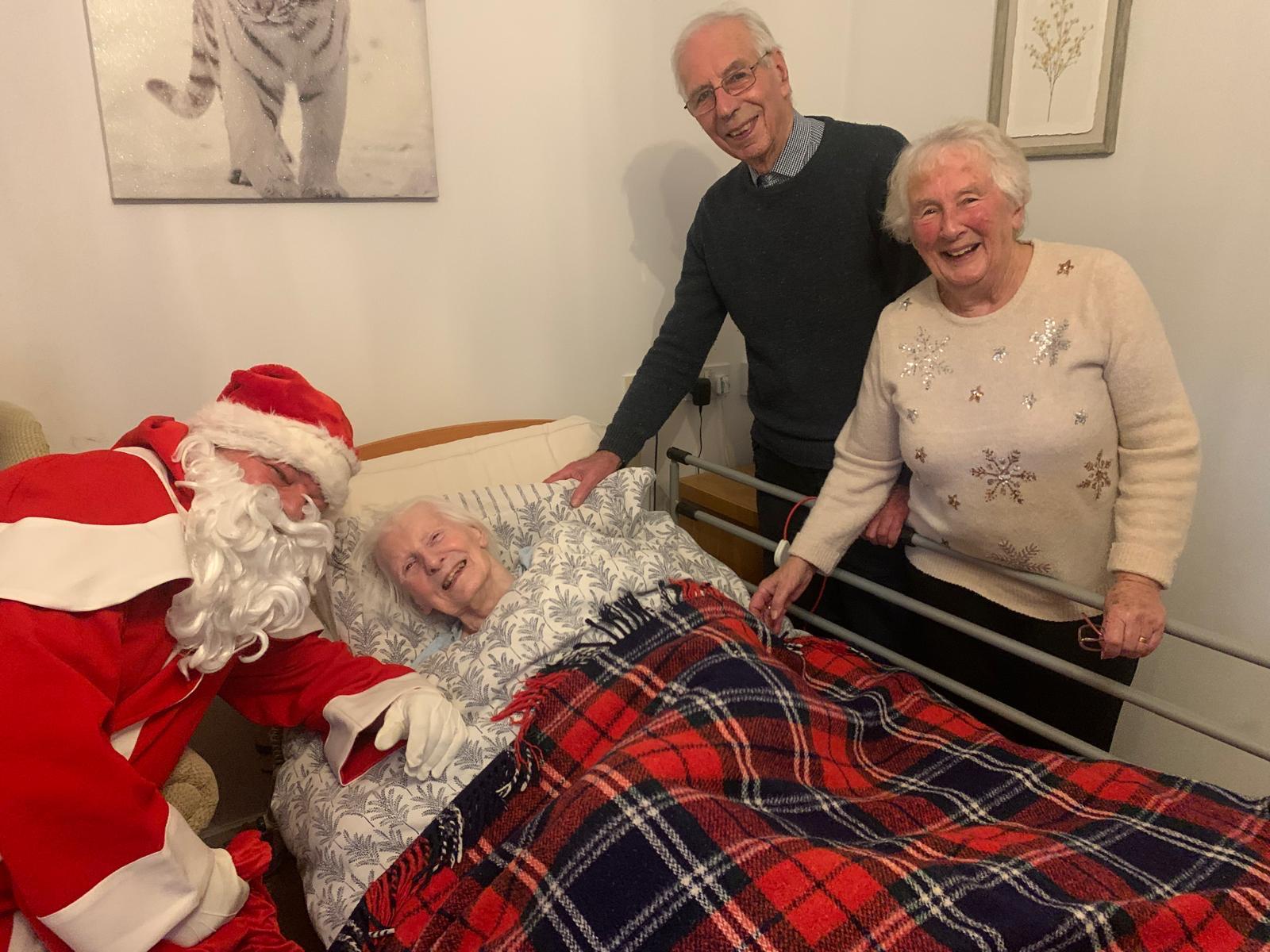 Residents with Santa in a cozy room setting