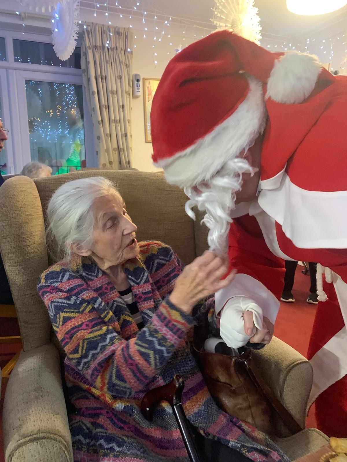 Resident interacting with a staff member dressed as Santa Claus