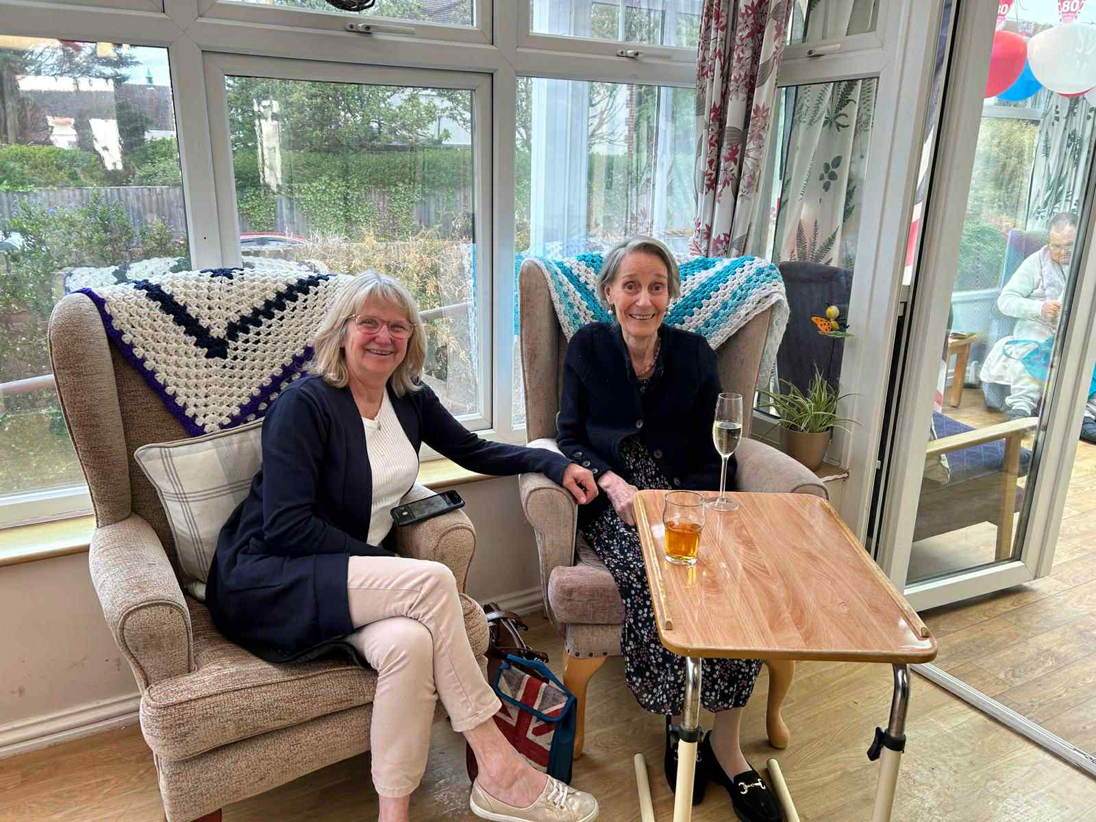 Two residents enjoying a shared space with drinks