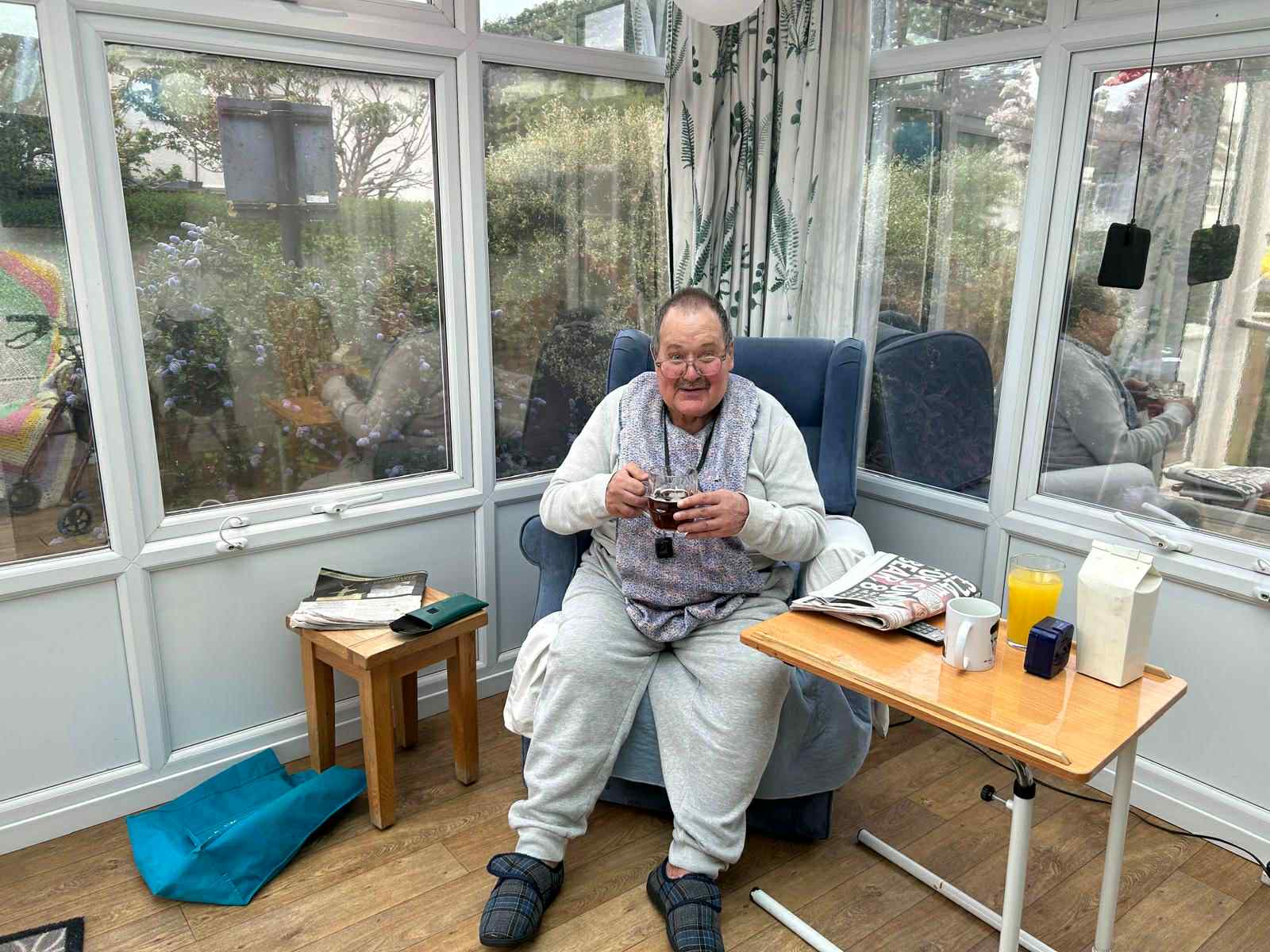 A resident enjoying a beverage in a sunlit room