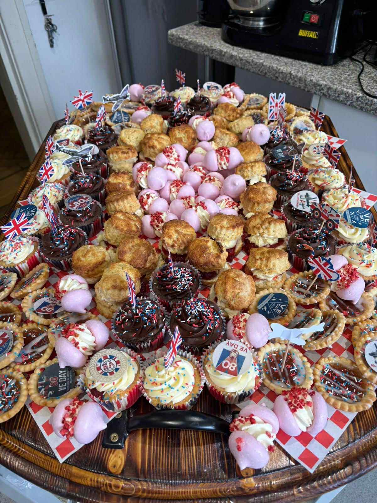 A variety of decorated cupcakes and pastries on a tray