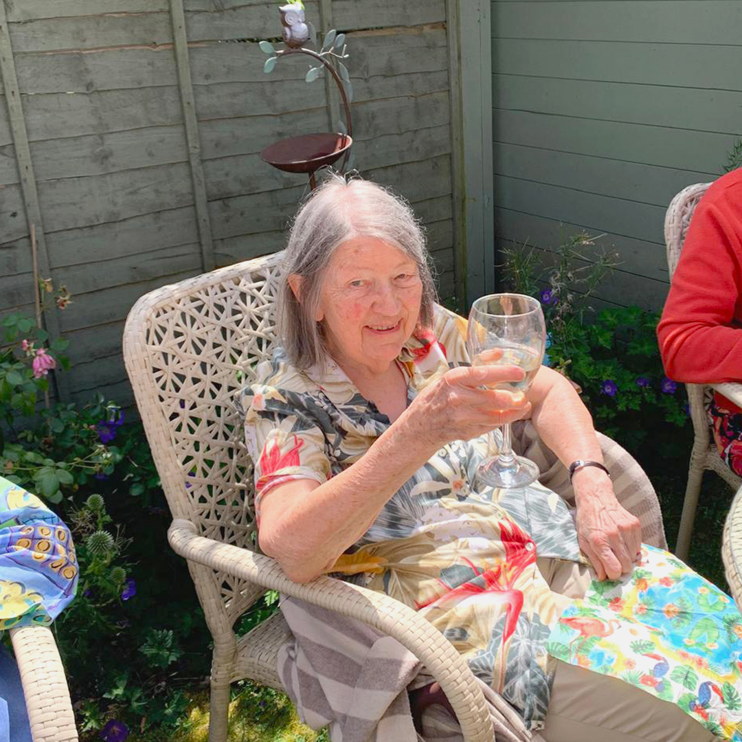 Senior resident enjoying a drink in the garden