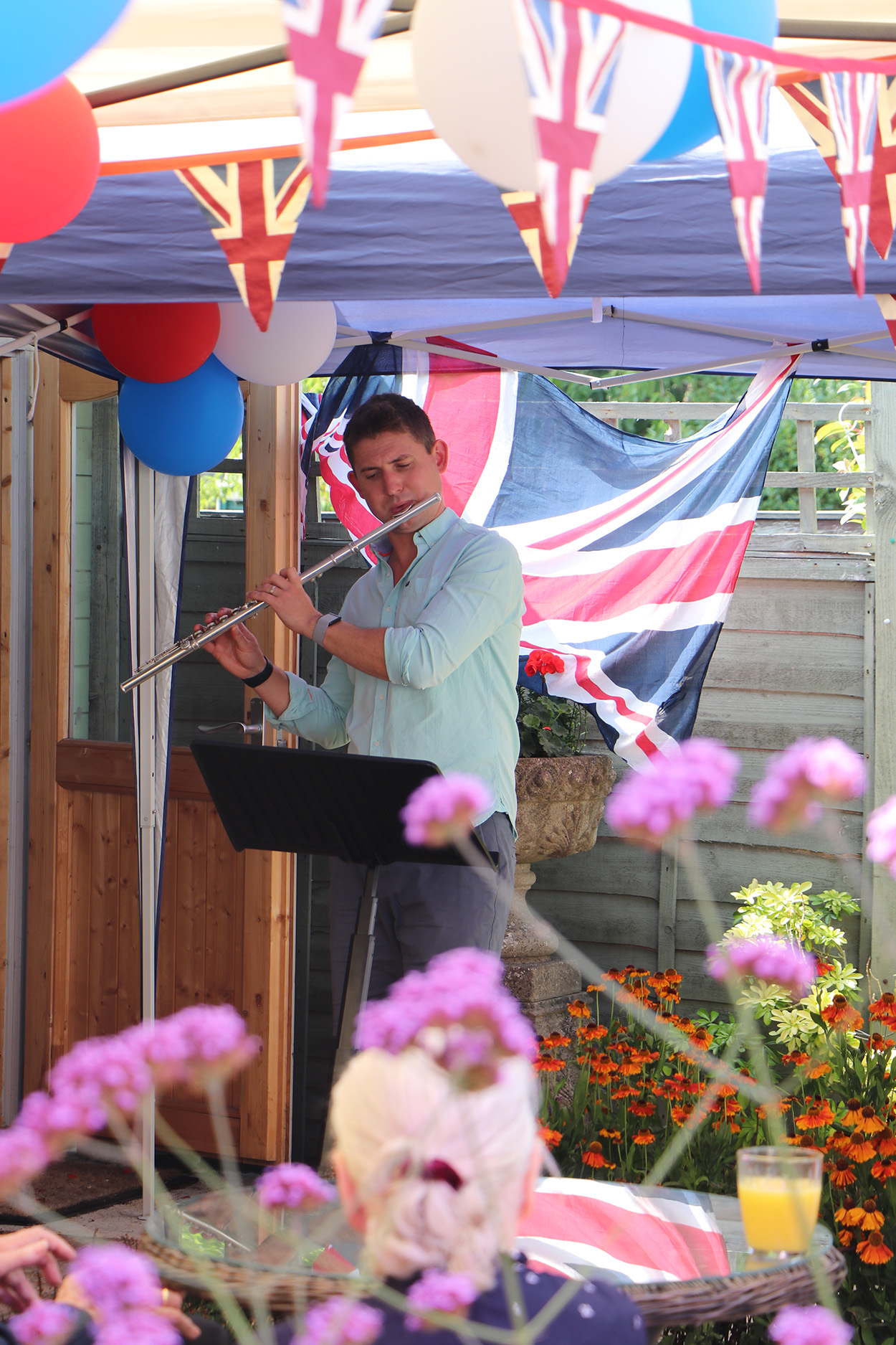 Musician performing outdoors with decorations in a garden setting