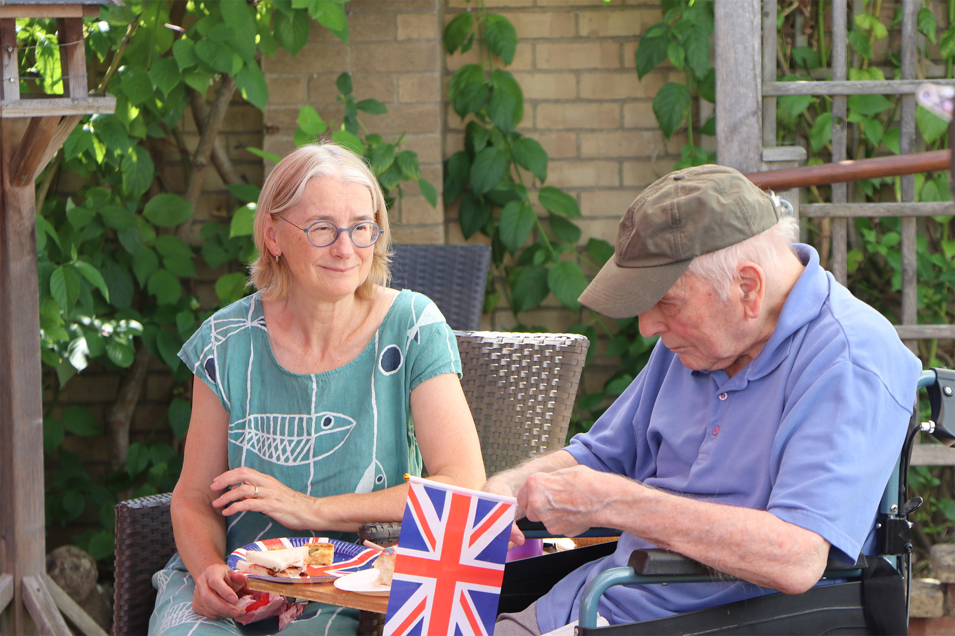 Residents enjoying snacks in an outdoor space with a flag