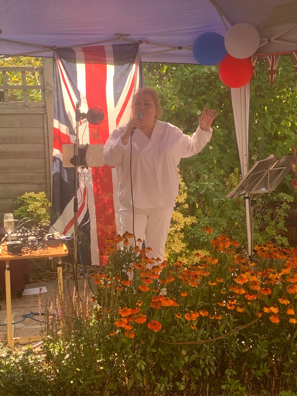 Performer singing at an outdoor event with decorations