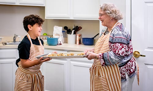 A senior woman and a child baking together in a kitchen