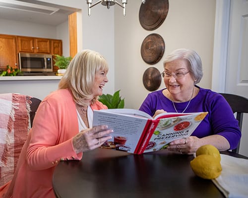 Two residents reading together in a cozy setting