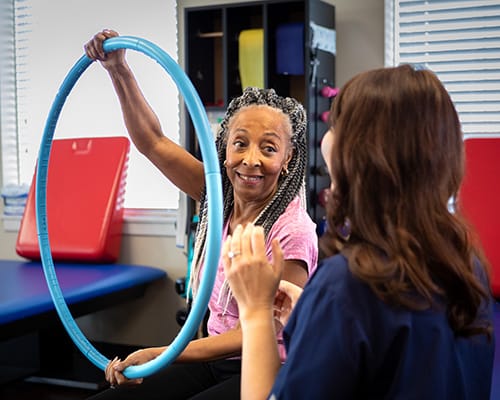 Resident engaging in therapy activity with staff member