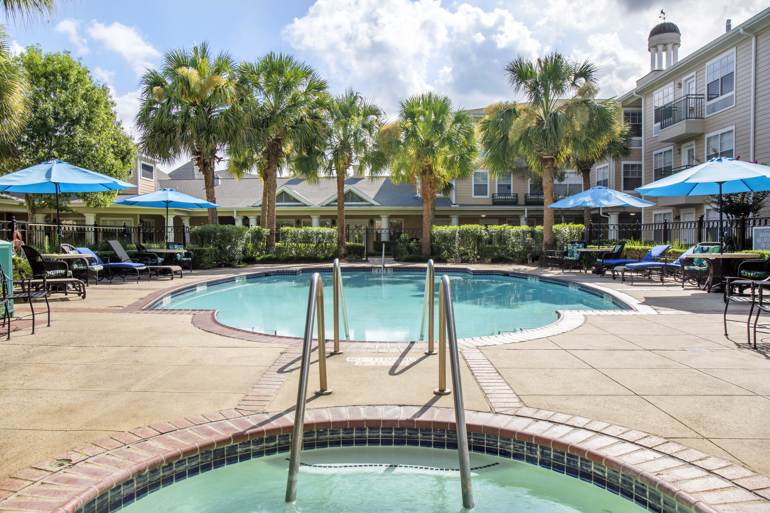 Swimming pool area with lounge chairs and umbrellas
