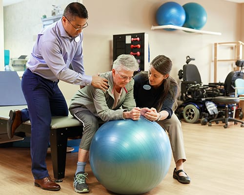 Therapists assisting a resident with exercise