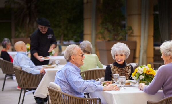 Residents enjoying a meal outdoors with food service